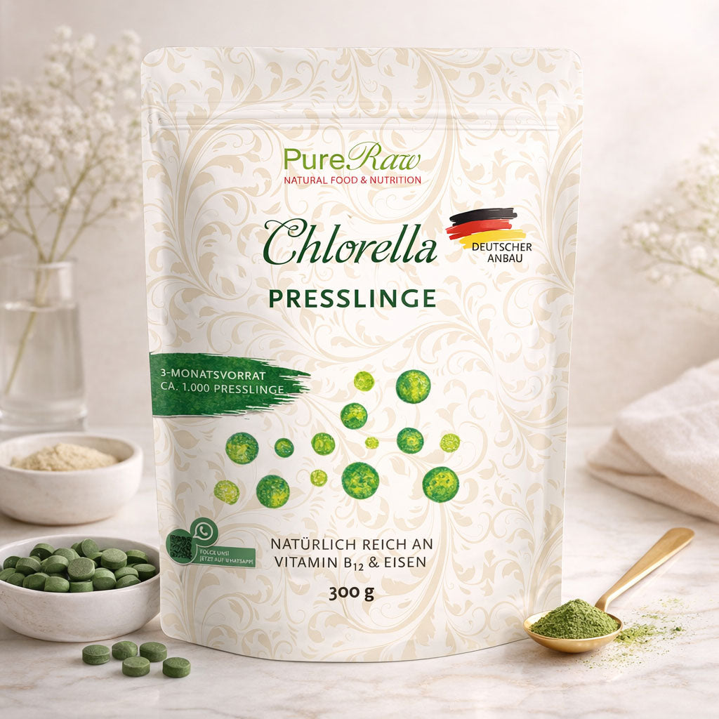 PureRaw Chlorella Presslinge dekorativ mit Schale, Löffel und grünen Presslingen arrangiert