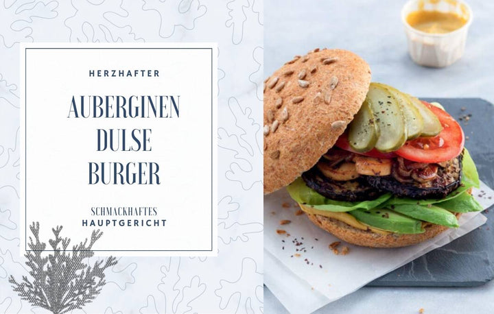 Herzhafter Auberginen-Dulse-Burger auf Vollkornbrötchen mit Salat, Tomaten, Gurken und cremiger Sauce, daneben Textfeld „Herzhafter Auberginen Dulse Burger – Schmackhaftes Hauptgericht“ auf algenartigem Hintergrund.