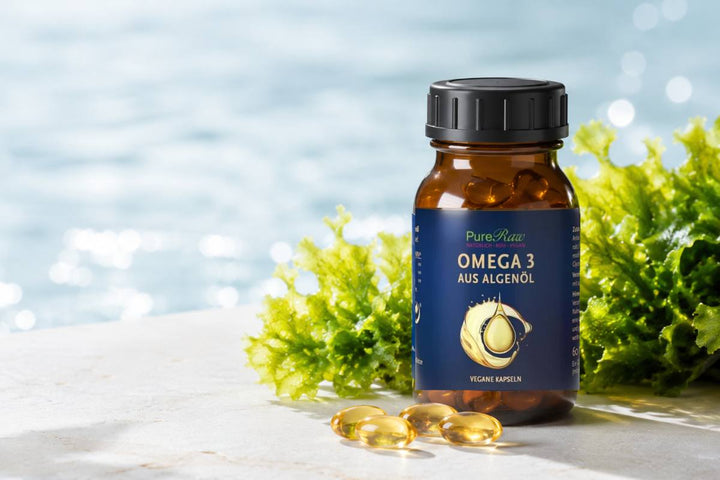  PureRaw Omega-3 aus Algenöl im Braunglas mit goldenen Kapseln und frischen grünen Algen vor hellem Wasserhintergrund.