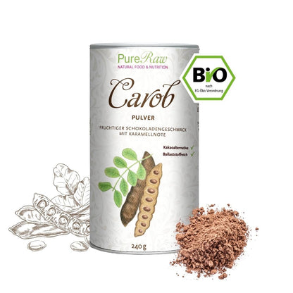 Weiße Dose mit der Aufschrift „PureRaw Carob Pulver“ neben getrockneten Johannisbrotschoten und einem kleinen Haufen Carobpulver