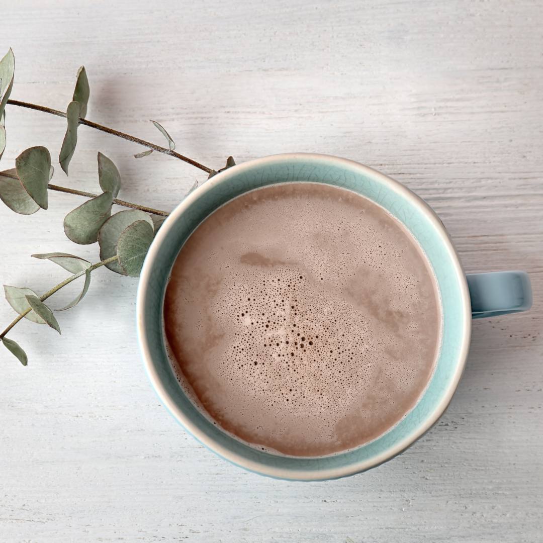Cremiger MaKao Kakao-Maca-Drink in einer türkisfarbenen Tasse