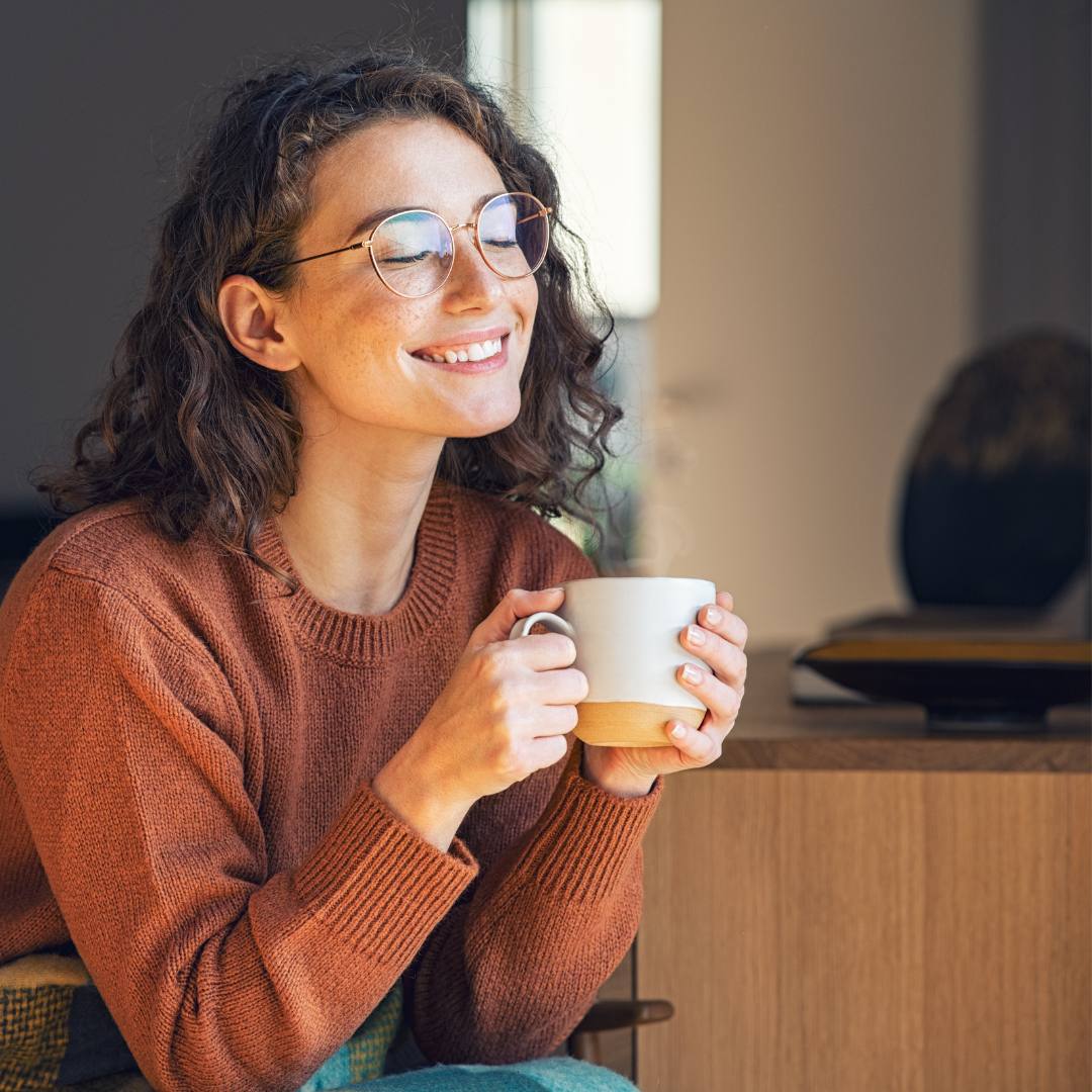 Frau genießt eine Tasse koffeinfreien Reishi Latte zu Hause