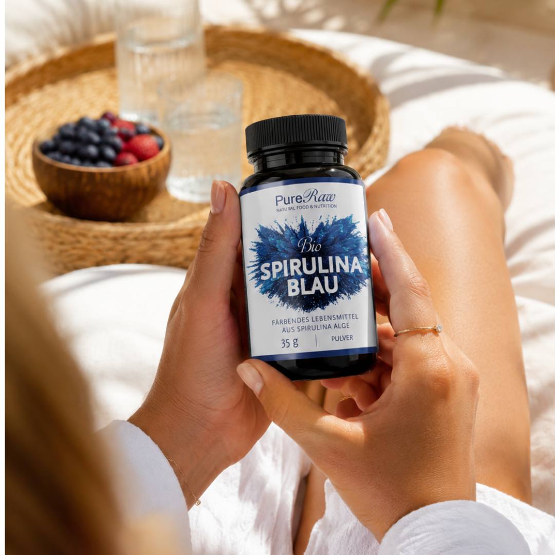 Person hält eine Dose PureRaw Bio Spirulina Blau vor einer Frühstücksbowl