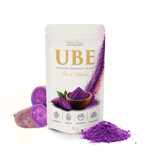 PureRaw Ube Pulver mit aufgeschnittener violetter Yamswurzel und einem Häufchen violettem Pulver.